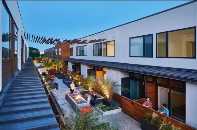 a group of people sitting in front of houses