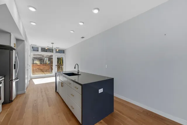 a kitchen with granite countertop a sink and a refrigerator