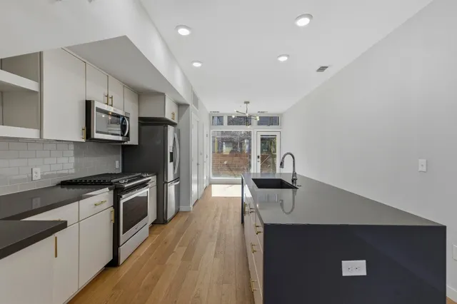 a kitchen with stainless steel appliances a sink stove and refrigerator
