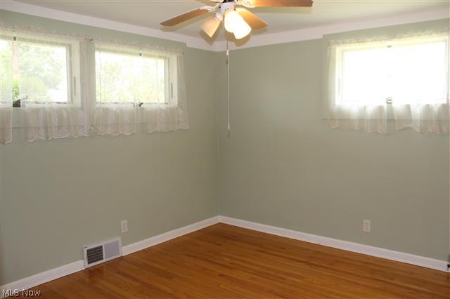 1438 Isler Circle Northwest Canton, OH 44708 - Photo 6 of 11 Bedroom 1 has wood floors and a ceiling fan with lights.