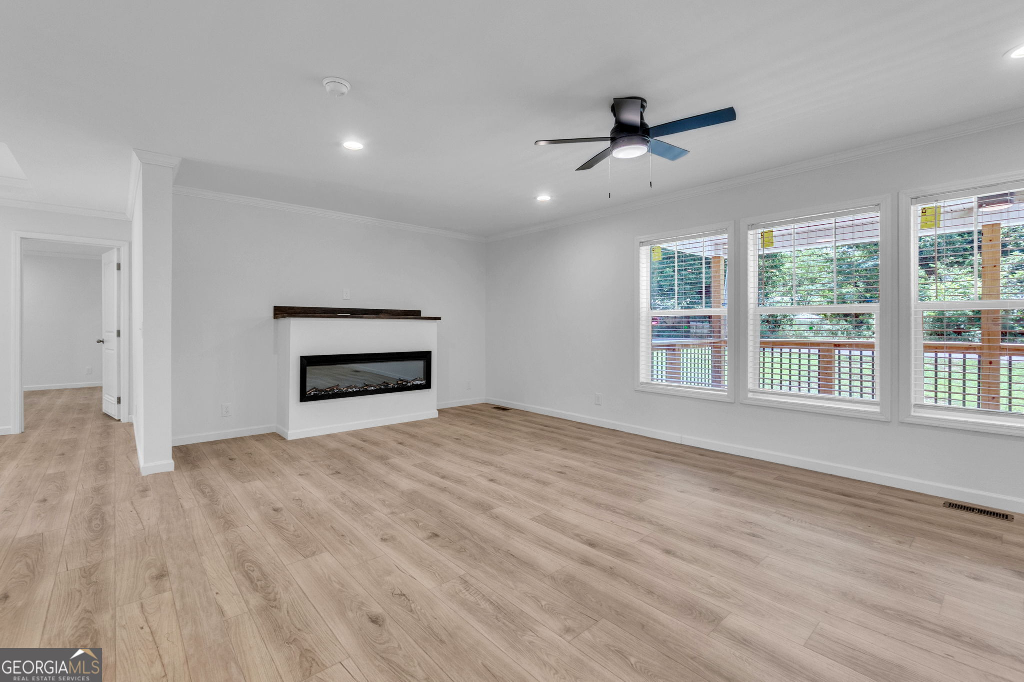108 Old River Road Iva, SC 29655 - Photo 7 of 31 an empty room with wooden floor ceiling fan and windows