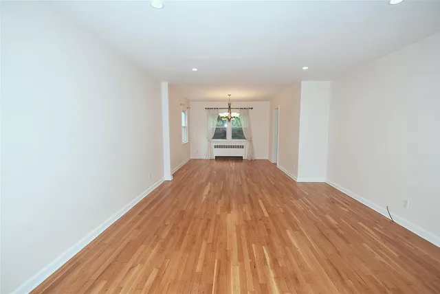 a view of a big room with wooden floor and windows