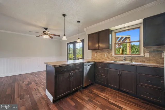a kitchen with stainless steel appliances granite countertop a sink cabinets and wooden floor