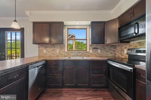 a kitchen with cabinets a window and stainless steel appliances