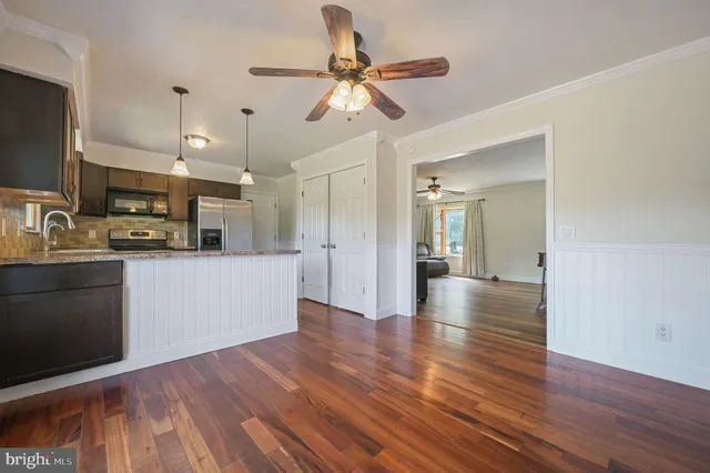 a view of a kitchen with wooden floor and a window