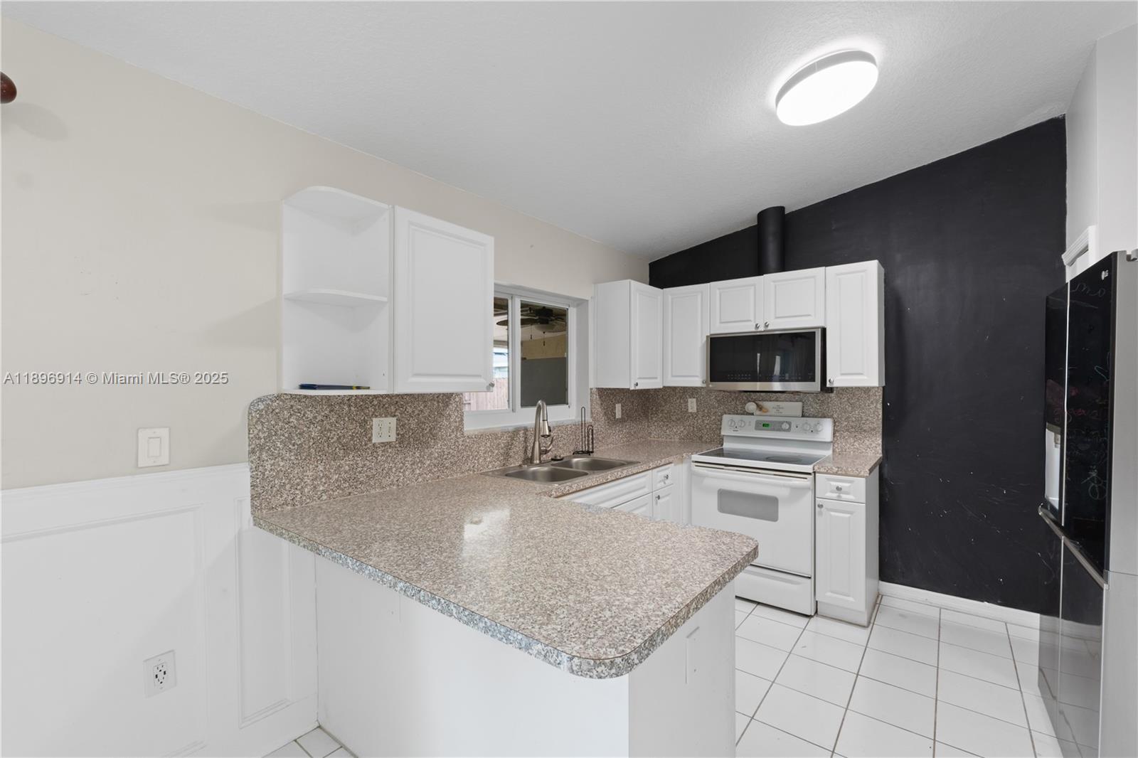 15327 Southwest 179th Terrace Miami, FL 33187 - Photo 3 of 29 a kitchen with stainless steel appliances granite countertop a sink stove and refrigerator