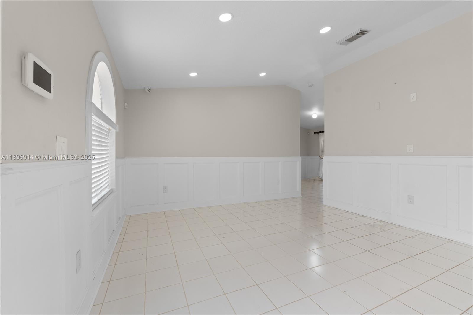 15327 Southwest 179th Terrace Miami, FL 33187 - Photo 7 of 29 an empty room with white walls and tiles