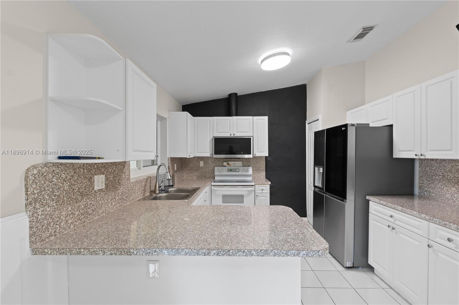 15327 Southwest 179th Terrace Miami, FL 33187 - Photo 10 of 29 a kitchen with stainless steel appliances granite countertop a sink refrigerator and microwave