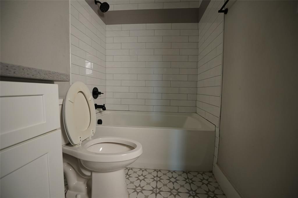 1764 Palladio Loop Princeton, TX 75407 - Photo 28 of 40 Bathroom featuring a white subway tile shower surround with matte black fixtures, a white bathtub, and patterned floor tiling