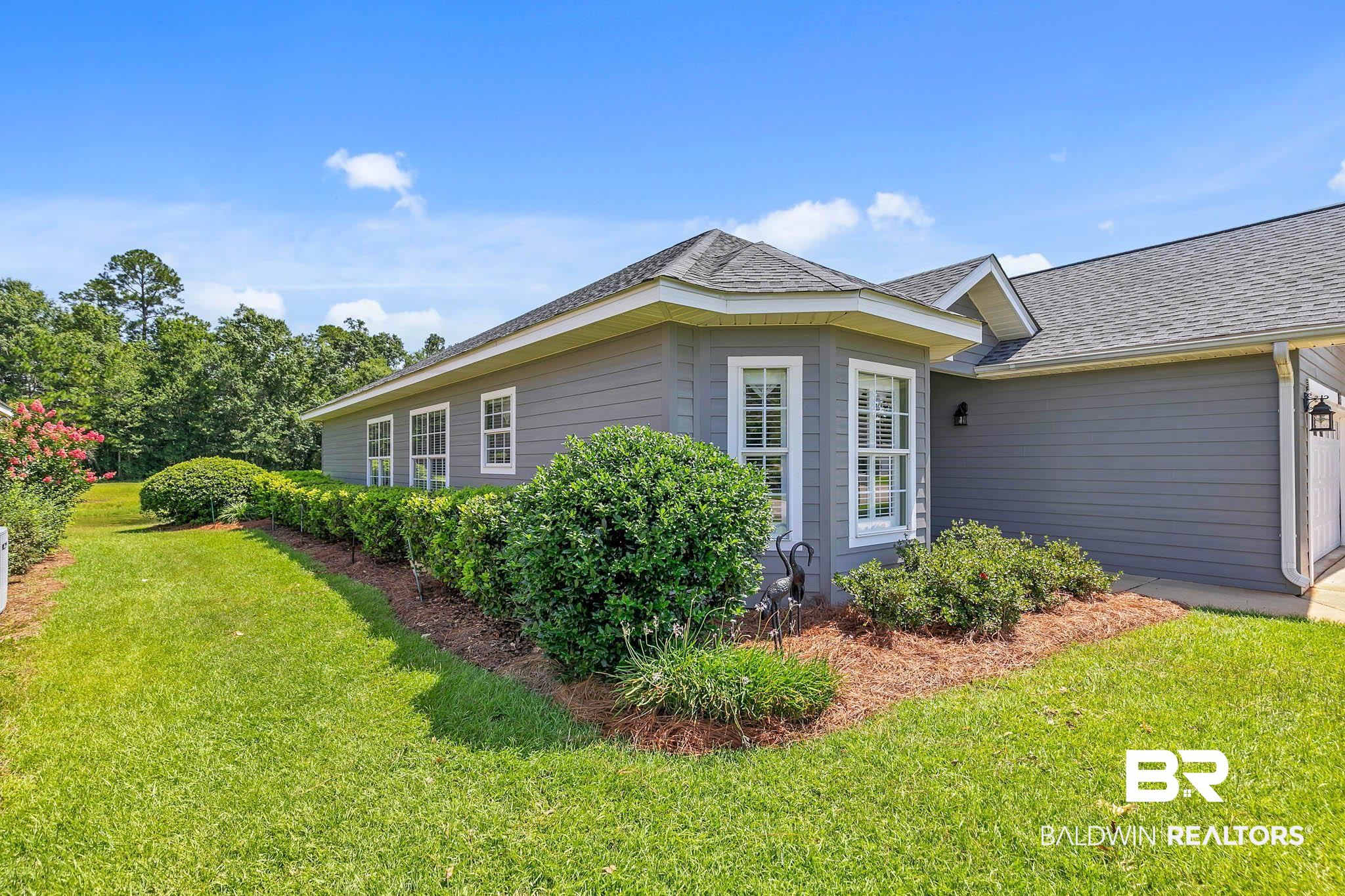 213 Hemingway Loop Foley, AL 36535 - Photo 5 of 69 View of side of property featuring a lawn and roof with shingles