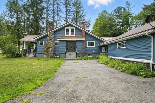 a front view of a house with yard and green space
