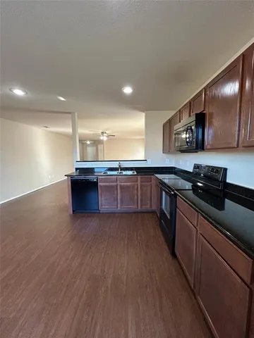 a large kitchen with stainless steel appliances and wooden cabinets