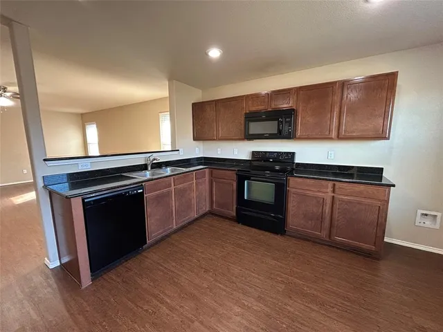 a kitchen with stainless steel appliances granite countertop a stove a sink and a microwave