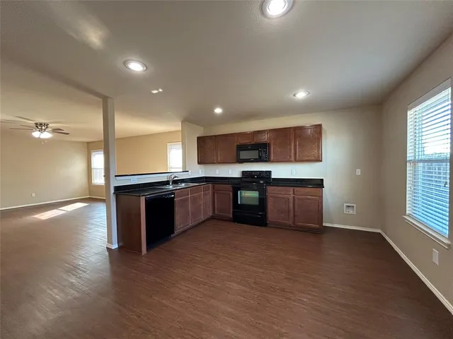 a large kitchen with a large counter top stainless steel appliances and cabinets