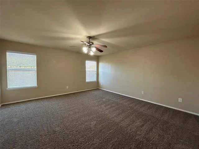 a view of an empty room with a chandelier fan