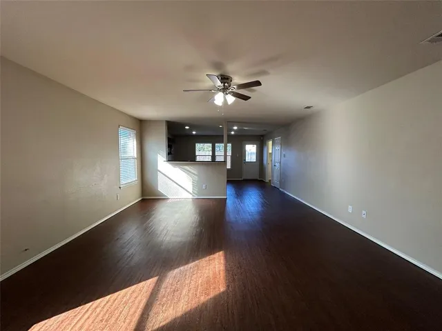 a view of a livingroom with wooden floor and a ceiling fan