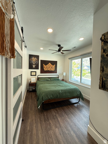 965 North 800 East Springville, UT 84663 - Photo 30 of 46 Bedroom featuring recessed lighting, a textured ceiling, dark wood-style floors, ceiling fan, and a barn door