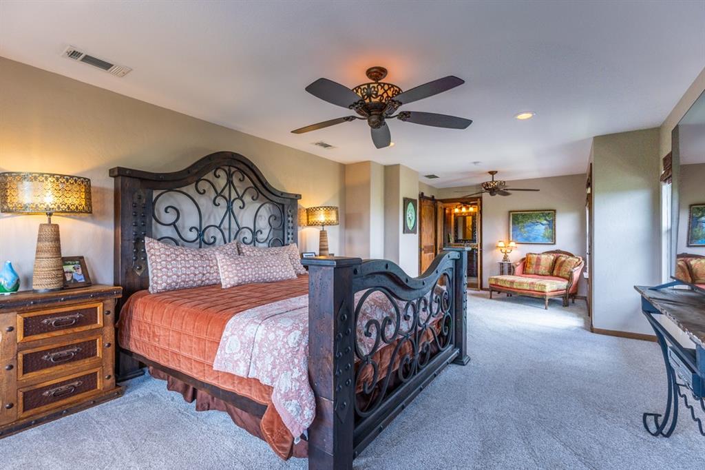 7060 Hells Gate Loop Strawn, TX 76475 - Photo 17 of 40 a bedroom with a bed and a chandelier