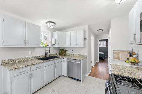 a kitchen with granite countertop white cabinets and appliances