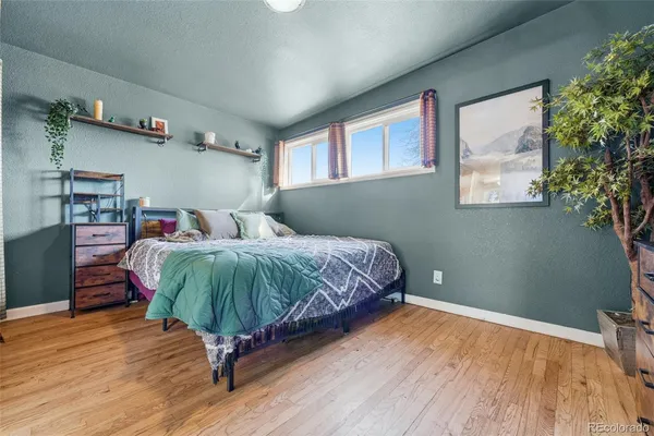 a bedroom with a bed and a wooden floor