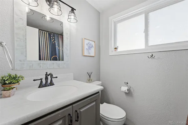 a bathroom with a sink a toilet and mirror