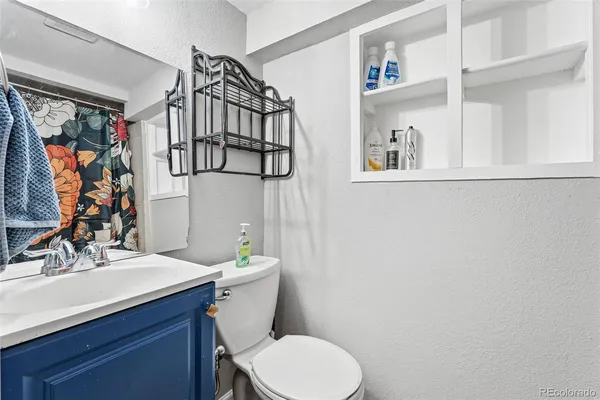 a bathroom with a sink vanity mirror and toilet