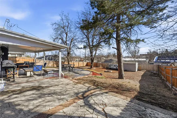 a view of a backyard with table and chairs under an umbrella