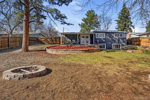 a view of a house with backyard and sitting area