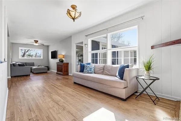 a living room with furniture and a wooden floor