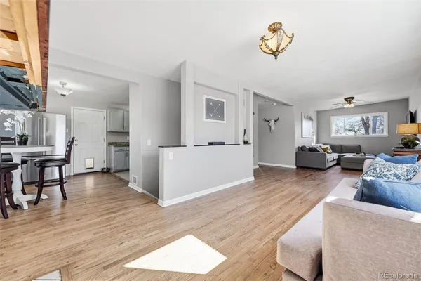 a living room with furniture and a wooden floor