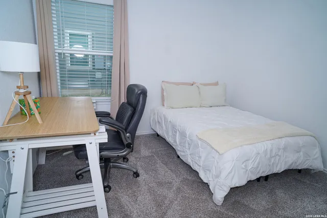a bedroom with a bed a desk and chair