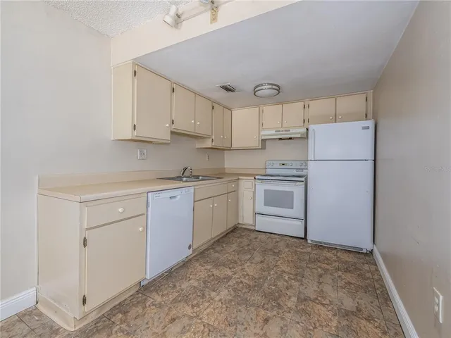 a kitchen with white cabinets and white appliances