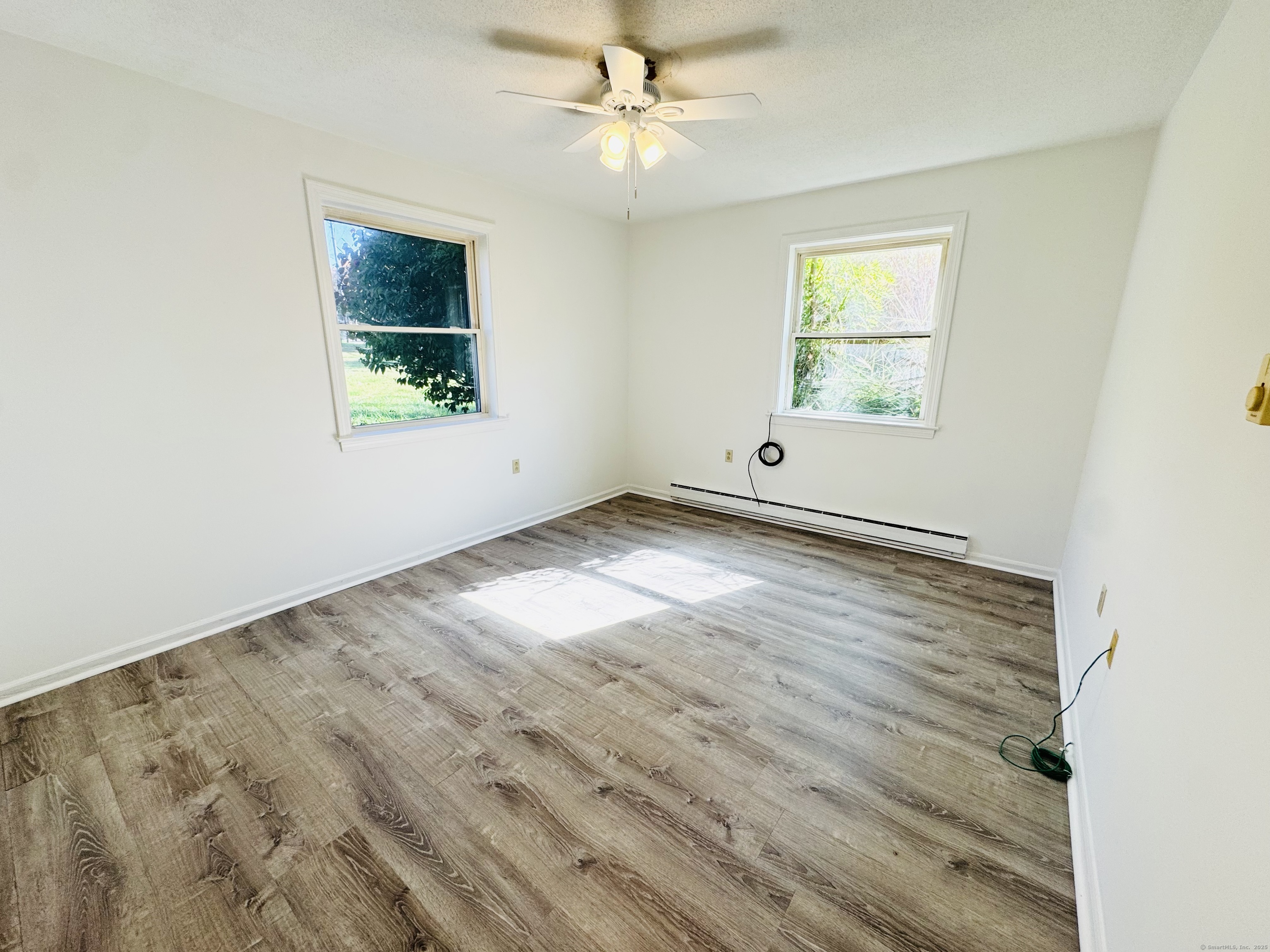 107 Niles Hill Road, Unit A New London, CT 06320 - Photo 13 of 22 an empty room with wooden floor and windows