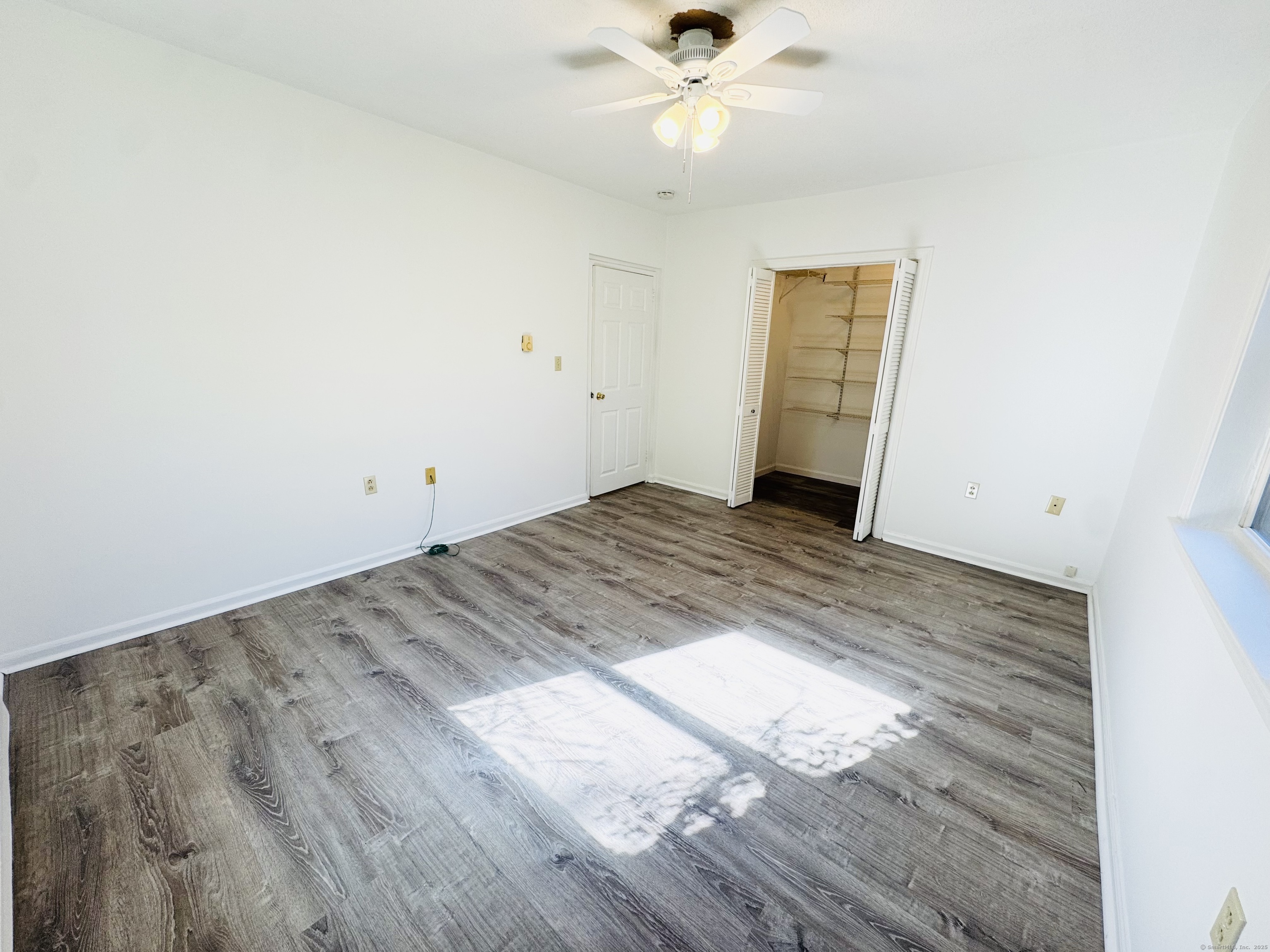 107 Niles Hill Road, Unit A New London, CT 06320 - Photo 15 of 22 an empty room with wooden floor fan and windows