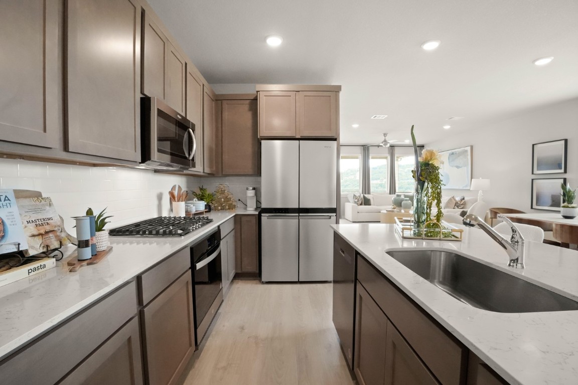 8112 Turning Leaf Circle Lago Vista, TX 78645 - Photo 9 of 29 a kitchen with a sink stove top oven and refrigerator