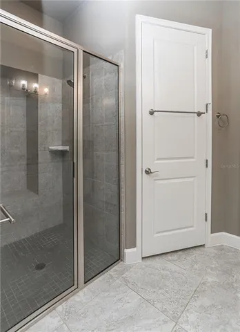 a bedroom with a bed next to a window with a chandelier