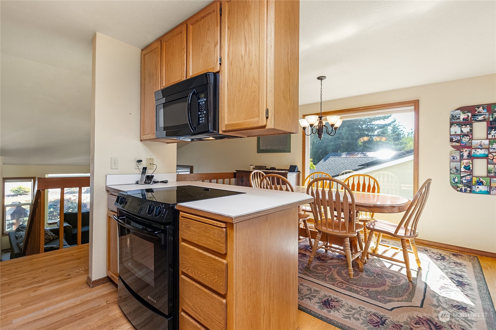 1388 Welling Road Bellingham, WA 98226 - Photo 14 of 40 a kitchen with stainless steel appliances granite countertop a stove top oven a sink a dining table and chairs with wooden floor
