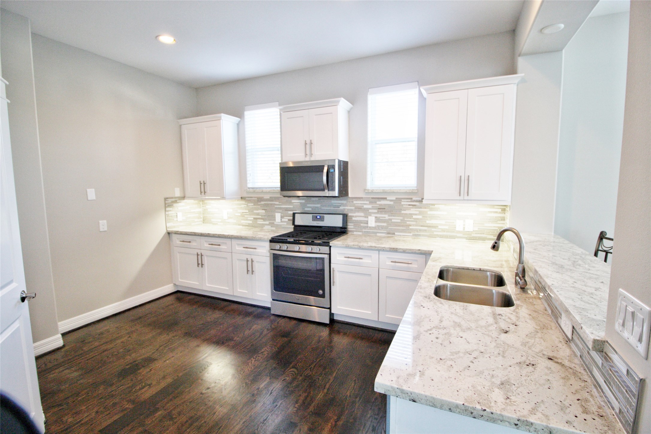709 Link Road Houston, TX 77009 - Photo 7 of 46 a kitchen with a sink dishwasher a stove and a refrigerator with wooden floor