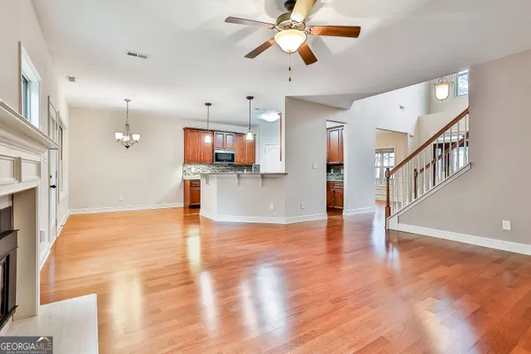 a kitchen with stainless steel appliances granite countertop a refrigerator a stove and a sink with wooden floor
