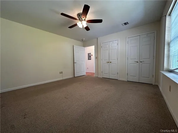 a view of a livingroom with a ceiling fan and window