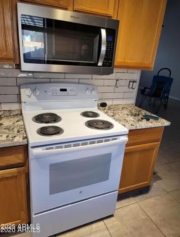 a stove top oven sitting inside of a kitchen