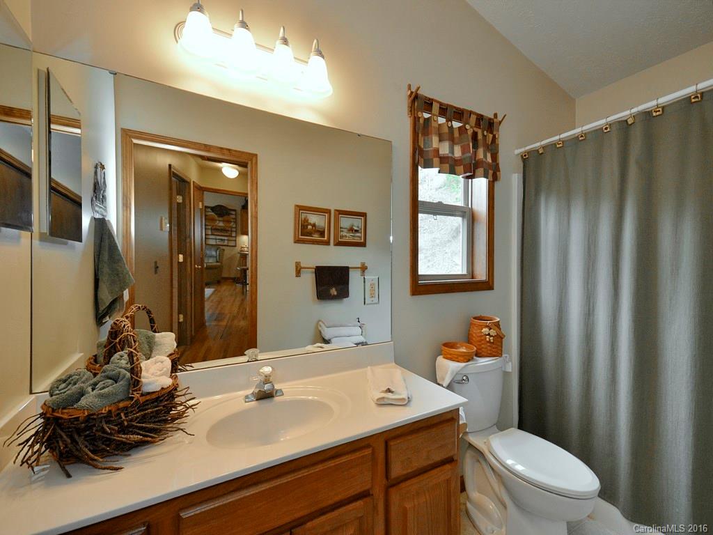 502 Sugar Cove Road Clyde, NC 28721 - Photo 13 of 24 a bathroom with a sink a toilet and shower curtain