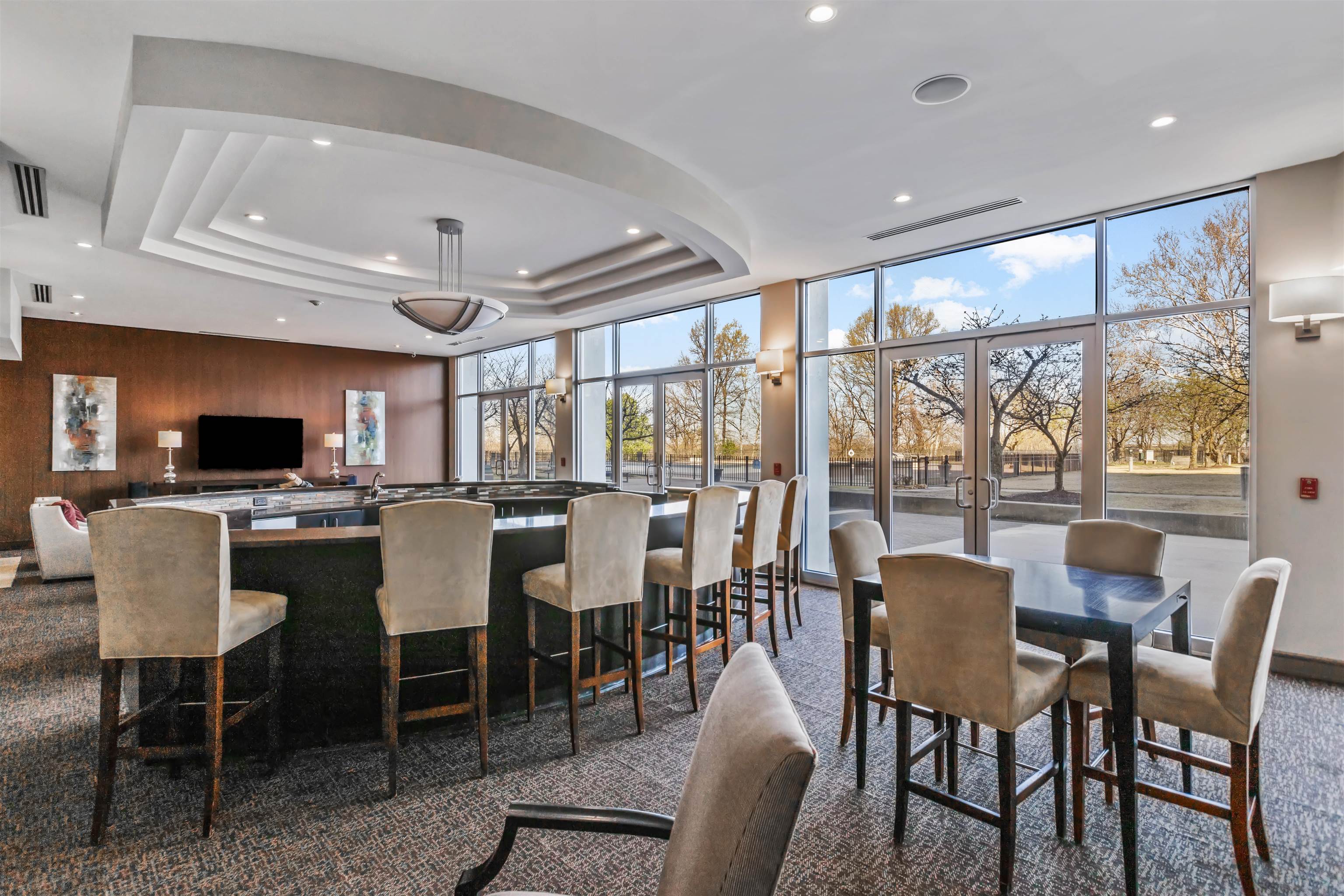 Dining area featuring dark colored carpet, recessed lighting, and a raised ceiling