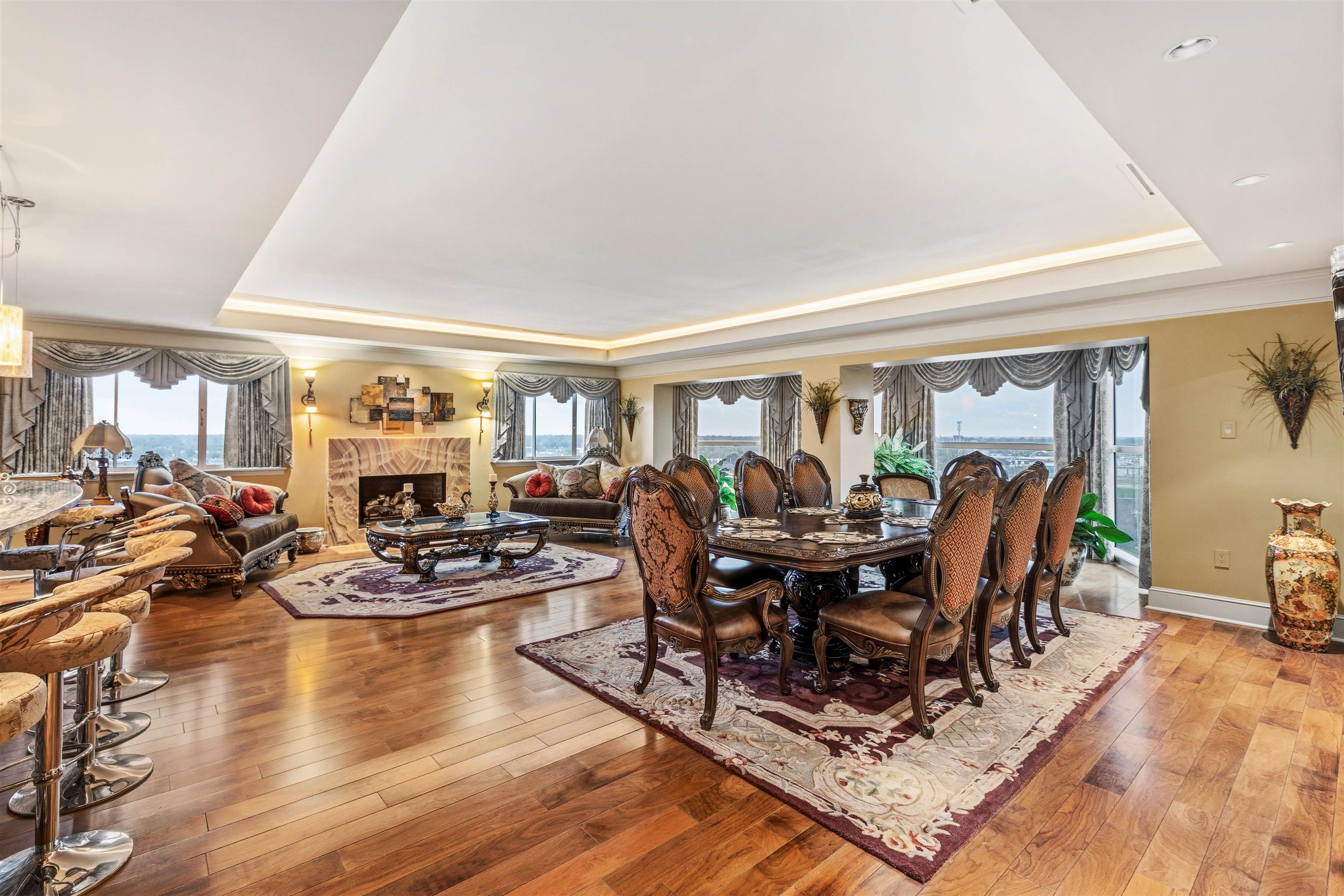 655 Riverside Drive, Unit 1208 Memphis, TN 38103 - Photo 14 of 29 Dining space featuring a tray ceiling, healthy amount of natural light, hardwood / wood-style floors, and a fireplace