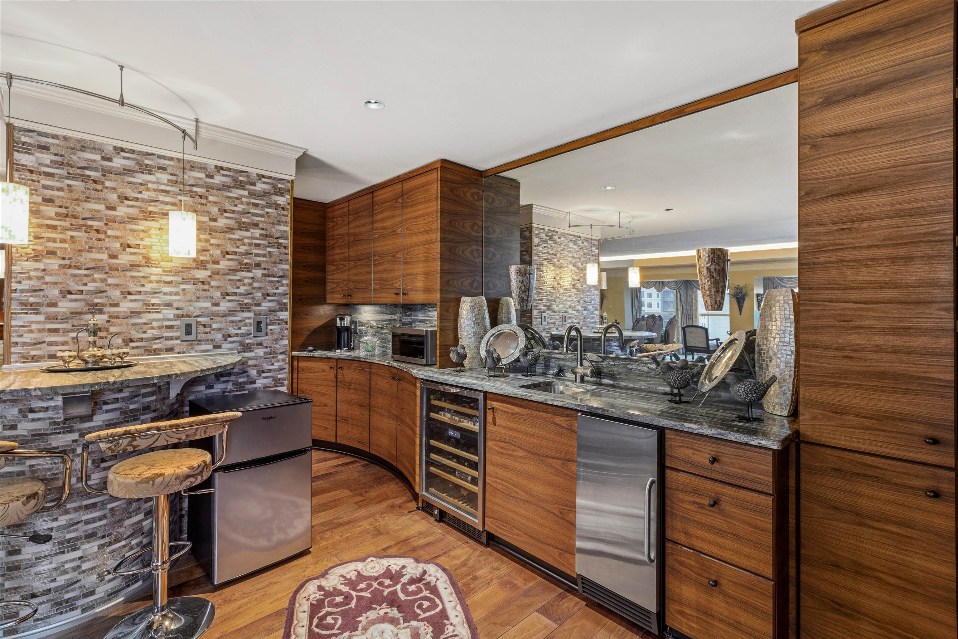 655 Riverside Drive, Unit 1208 Memphis, TN 38103 - Photo 20 of 29 Bar featuring dark stone counters, stainless steel fridge, beverage cooler, light wood-style flooring, and wood finish cabinetry