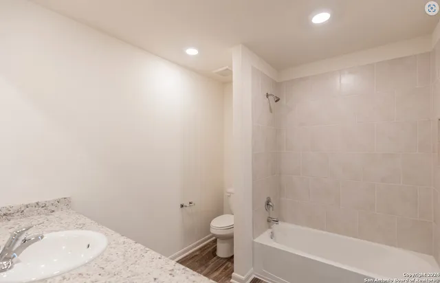 a bathroom with a tub sink toilet and a mirror