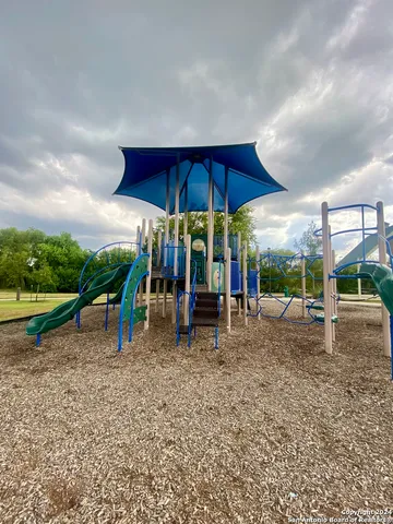 a view of a child park with large trees