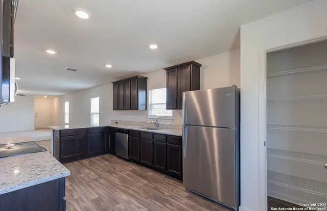 a kitchen with stainless steel appliances granite countertop a refrigerator and a sink