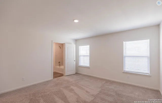 an empty room with windows and closet
