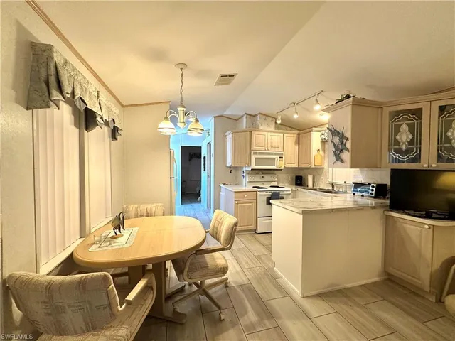 a kitchen with a table chairs refrigerator and microwave